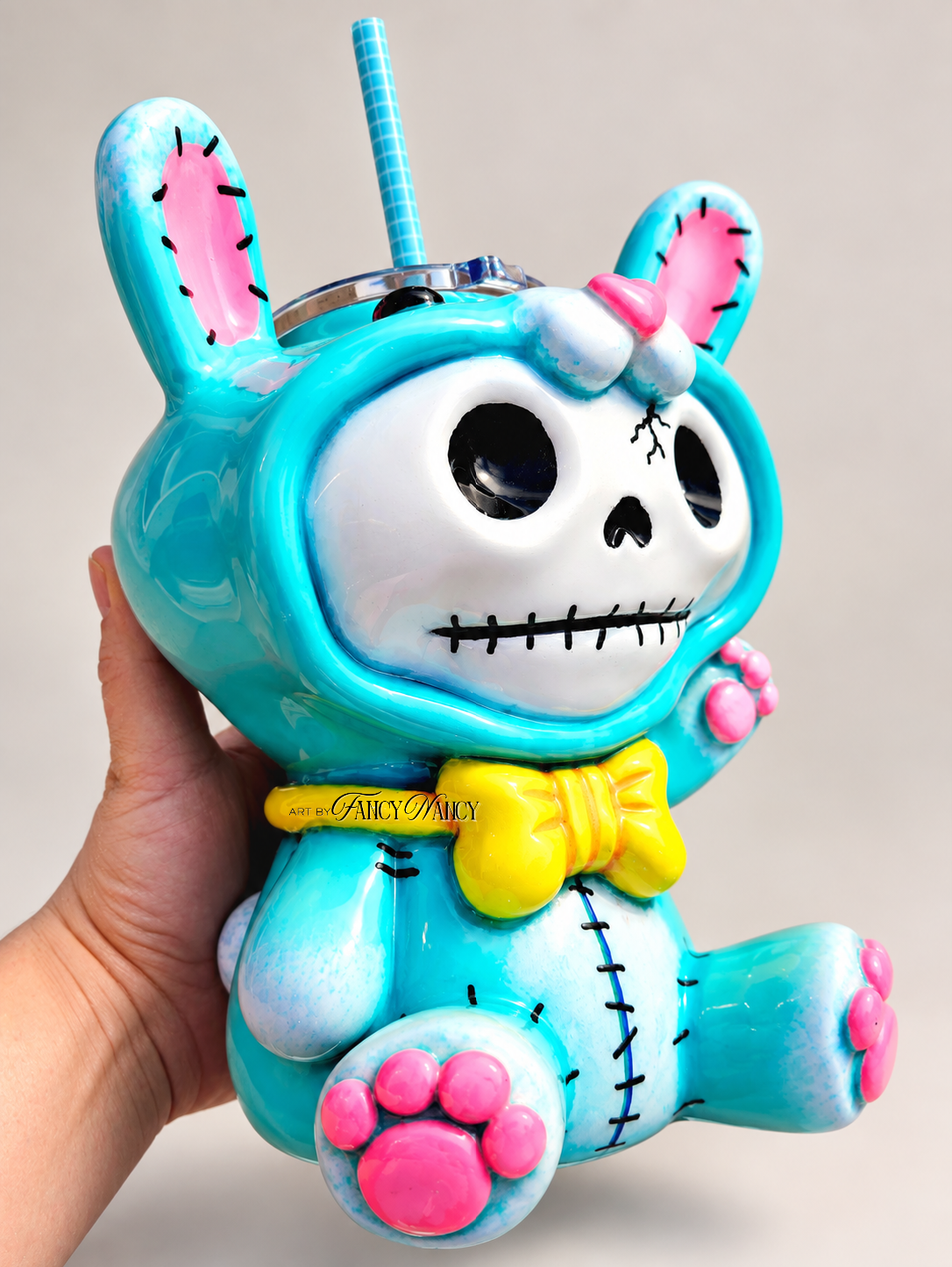 Alternate front angle of Funny Bunny skull bunny tumbler with pink paws and yellow bow tie